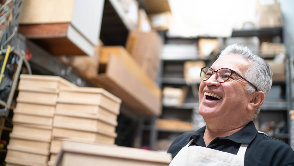 Smiling elderly man standing in front of storage boxes. Join the RentaNook Community Now